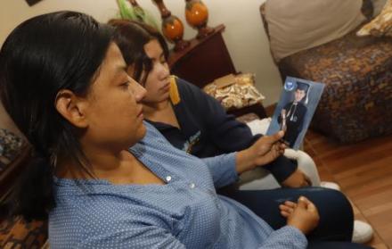 La madre de Carlos sostiene una foto de su hijo, recordándolo durante su época colegial.