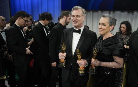 Christopher Nolan y su esposa, Emma Thomas, sostienen sus estatuillas doradas.