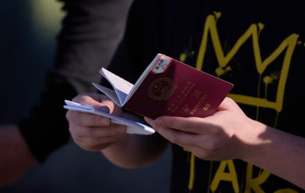 Un migrante sostiene su pasaporte para ser inspeccionado por la Patrulla Fronteriza de EE. UU.