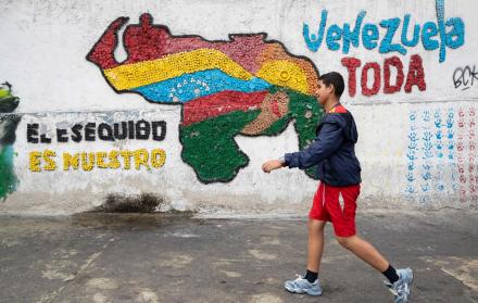 Fotografía del 2 de abril del 2025 de una persona caminando frente a un mural con el mapa de Venezuela en Caracas (Venezuela).