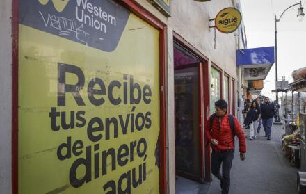 una persona que camina frente a un establecimiento de envío de dinero en Tijuana (México).