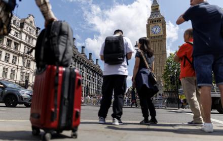 Una persona carga una maleta con la Torre Isabelina, comúnmente conocida como Big Ben, al fondo, en Parliament Square, Londres, Reino Unido, 12 de mayo de 2025.