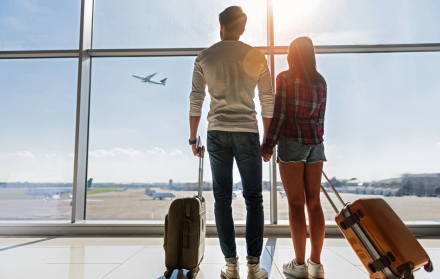 Referencial. Pareja esperando su vuelo en aeropuerto.
