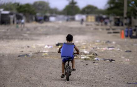 Un niño migrante venezolano monta su bicicleta en el campamento de migrantes La Pista en Maicao, departamento de La Guajira, Colombia, el 22 de abril de 2025.