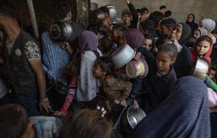Cientos de palestinos se amontonan frente al Comedor Social Sokar en la Ciudad de Gaza para conseguir raciones de comida.