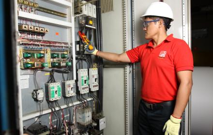 Un trabajador da mantenimiento eléctrico a una planta industrial