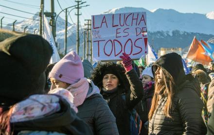 Mujer sostiene un cartel que dice