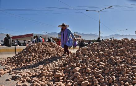 mujer captada al pasar sobre un montículo de piedras en Cochabamba (Bolivia).