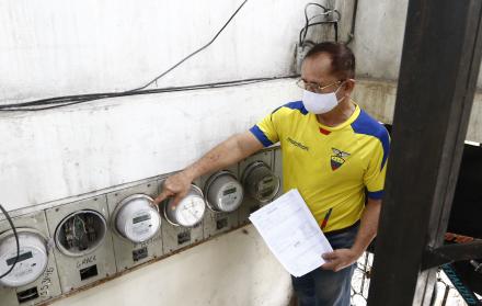 UN USUARIO HOMBRE MUESTRA SUS MEDIDORES DE ENERGÍA ELÉCTRICA Y SUS PLANILLAS DE CONSUMO |