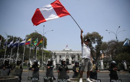 Fotografía de un hombre al ondear una bandera peruana