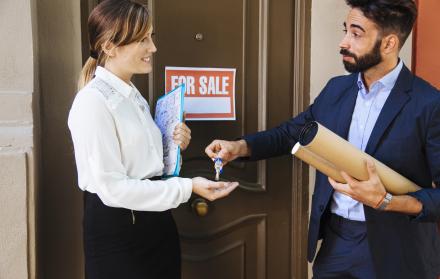 agente-inmobiliario-dando-llave-mujer-de-negocios