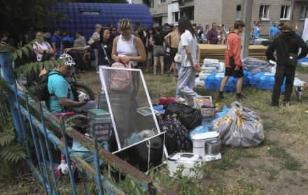 Residentes cerca de un edificio residencial dañado en Dnipropetrovsk, Ucrania
