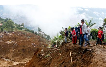 Personas observan la zona afectada por una riada
