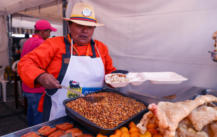 Fotografía de archivo fechada el 09 de agosto de 2024 de una mujer sirviendo alimentos típicos en Quito (Ecuador).