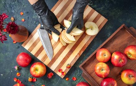 vista-superior-cocinera-cortando-manzanas-en-la-superficie-gris