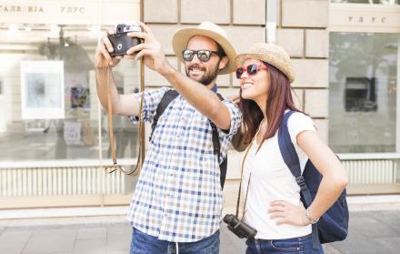 pareja-con-gafas-de-sol-y-sombrero-tomando-selfie-en-camara