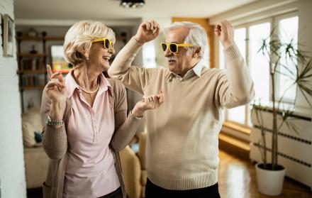 alegre-pareja-de-ancianos-con-gafas-de-sol-bailando-y-divirtiendose-juntos-en-casa