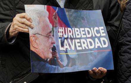 Persona que sostiene un cartel de Uribe