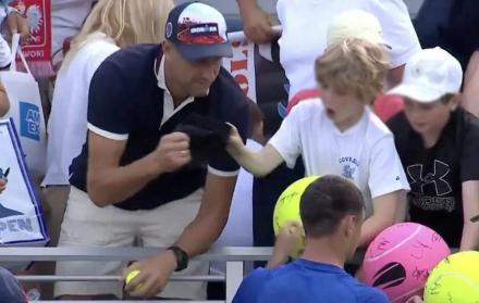 Piotr Szczerek, director ejecutivo de la empresa polaca Drogbruk en el momento que le arrebata la gorra al niño.