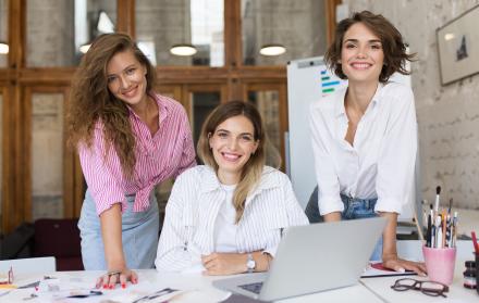 grupo-de-jovenes-mujeres-alegres-con-laptop-felizmente-mirando-en-camara