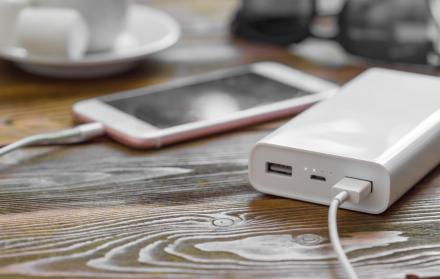 powerbank-y-telefono-movil-en-mesa-de-madera