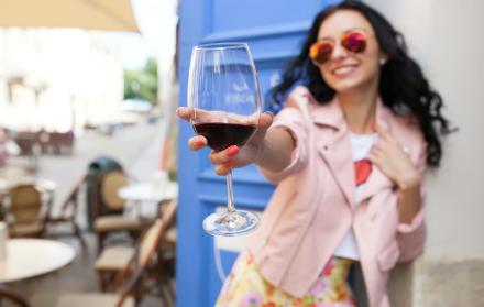 atractiva-mujer-joven-bebiendo-vino-en-las-vacaciones-de-verano-sentado-en-el-cafe-de-la-calle-de-la-ciudad-en-traje-fresco