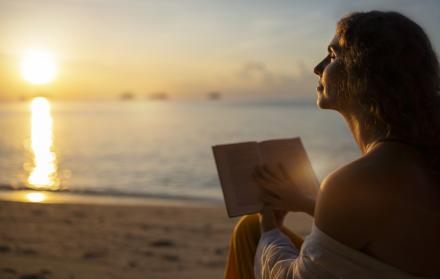 mujer-leyendo-en-la-vista-lateral-de-la-playa