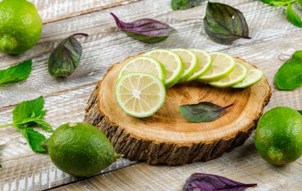 los-limones-con-albahaca-se-van-en-la-tabla-de-madera-y-de-corte-opinion-de-alto-angulo