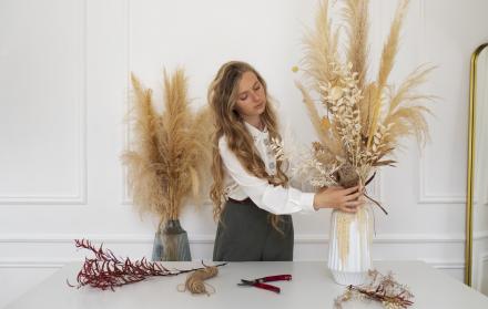 mujer-trabajando-con-plantas-secas-plano-medio