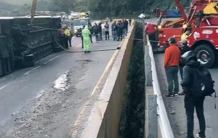 Los bomberos y la policía cercaron la zona del accidente en la vía Alóag - Santo Domingo, mientras se removía el bus volcado.