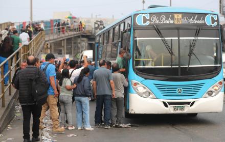 Personas hacen fila para subir a un bus en Perú