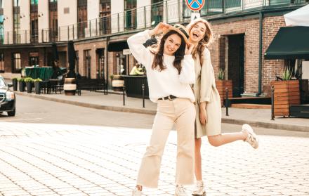 two-young-beautiful-smiling-hipster-female-trendy-white-sweater-coat