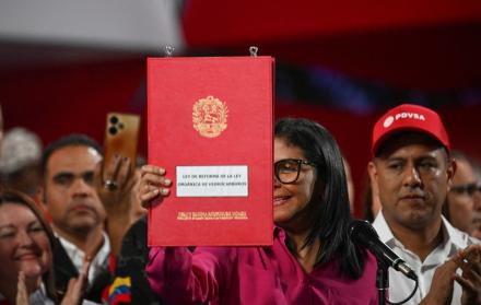 La presidenta interina de Venezuela, Delcy Rodríguez, sostiene una copia de la reforma.