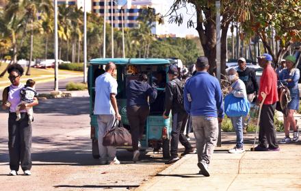 Personas suben a un vehículo eléctrico en La Habana