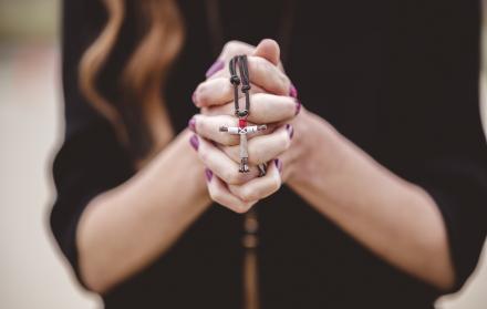 Mujer con rosario en las manos