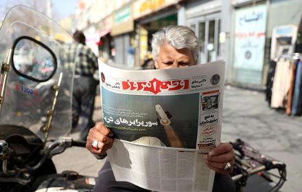 un hombre lee el diario iraní  con el titular 