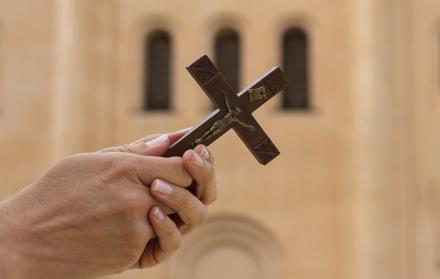 woman-holding-crucifix-church