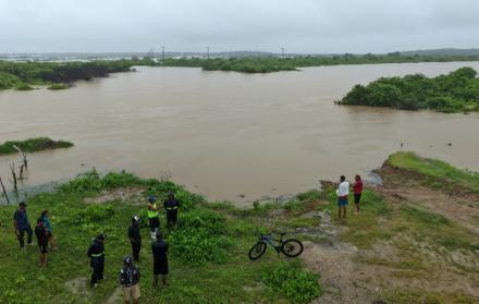 Fotografía aérea que muestra a personas observando las inundaciones en la localidad de Chanduy en Santa Elena.