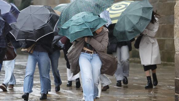 Varias personas se protegen de la lluvia