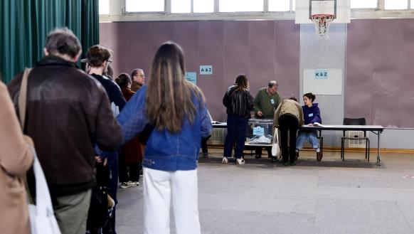 Personas hacen cola para votar en un colegio electoral