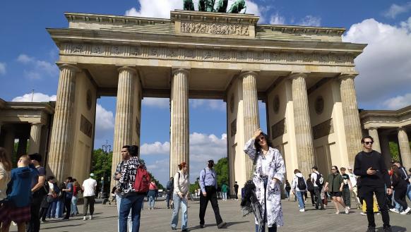 Personas caminan frente a la Puerta de Brandeburgo.