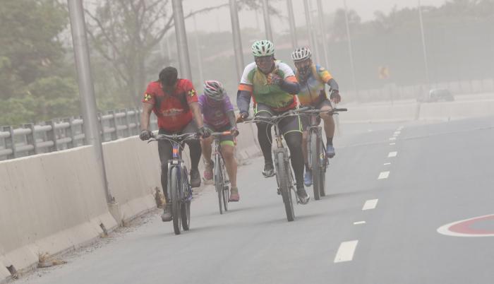 Ciclistas conducen en medio de las partículas del Sangay, en Guayaquil.