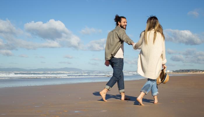 side-view-of-caucasian-couple-on-summer-vacation-bearded-man-and-woman-in-casual-clothes-walking-on-beach-holding-hands-love-travelling-tenderness-concept