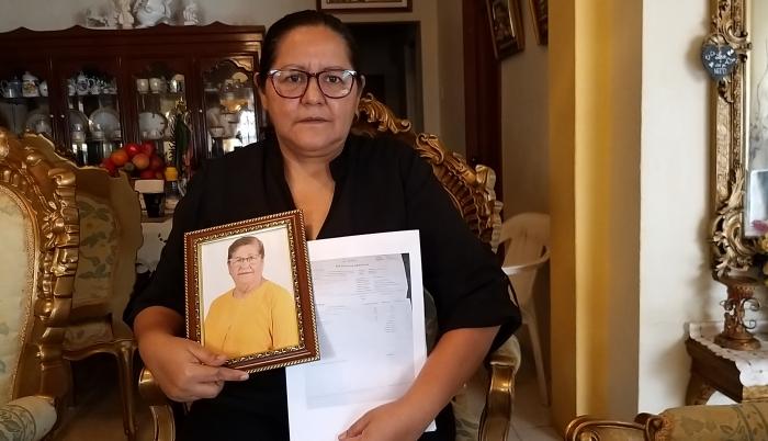 Elsa Maldonado sostiene un retrato de su madre y los papeles de defunción.