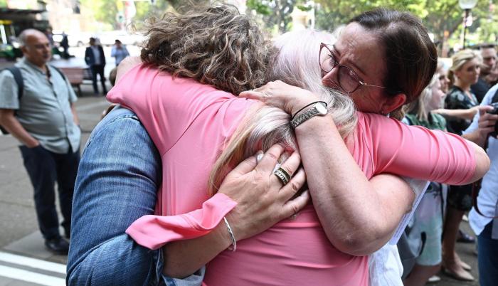 Tres mujeres se abrazan tras conocer la sentencia de la demanda colectiva.
