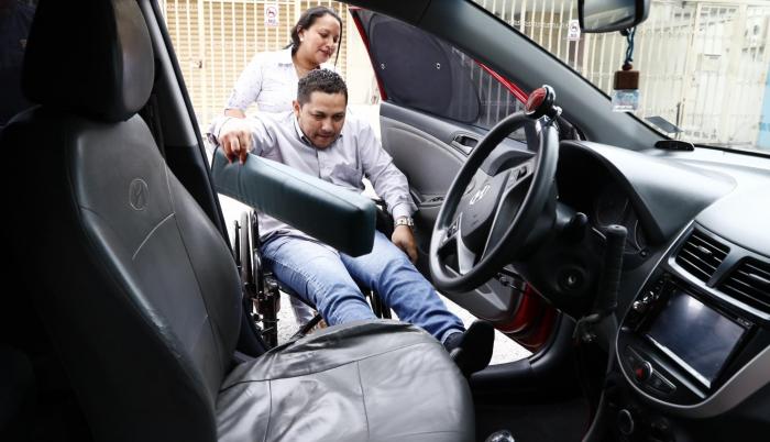Apoyo. Alexandra Mero ayuda a su esposo Darwin Plaza a embarcarse en el auto que invirtió. Vuelve a tomar el volante después de dos años del accidente.