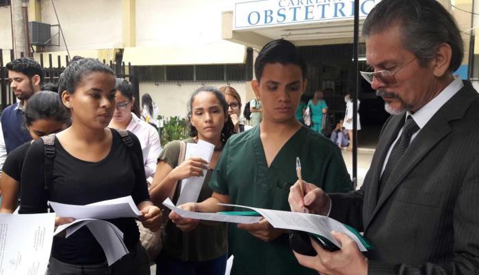 El abogado de los estudiantes recoge firmar para exigir la revisión de la providencia emitida por el juez.