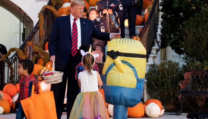 Trump coloca un chocolate en la cabeza de un niño, en lugar de en su funda de caramelos.
