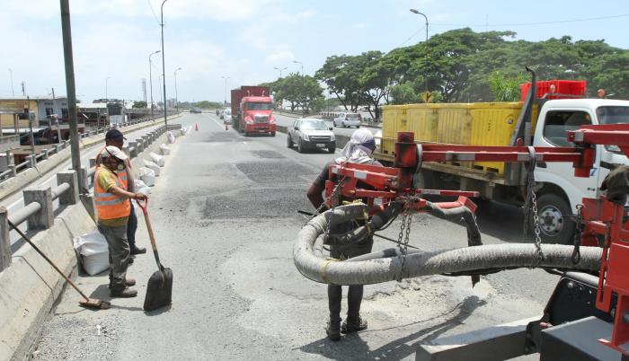 Flavio Alfaro. Personal del Municipio cumple con trabajos de bacheo en la rampa de bajada hacia la vía a Daule, lo que obligó el cierre parcial y con ello la lenta circulación vehicular. El deterioro de la carpeta asfáltica es permanente.