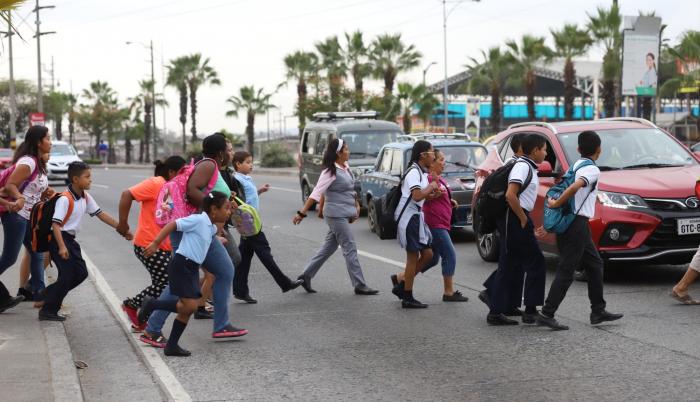 Dificultades. Los padres y alumnos que acuden a planteles de Mucho Lote 1 les toca correr para llegar a la otra vereda. Insisten en la construcción de un paso peatonal elevado.